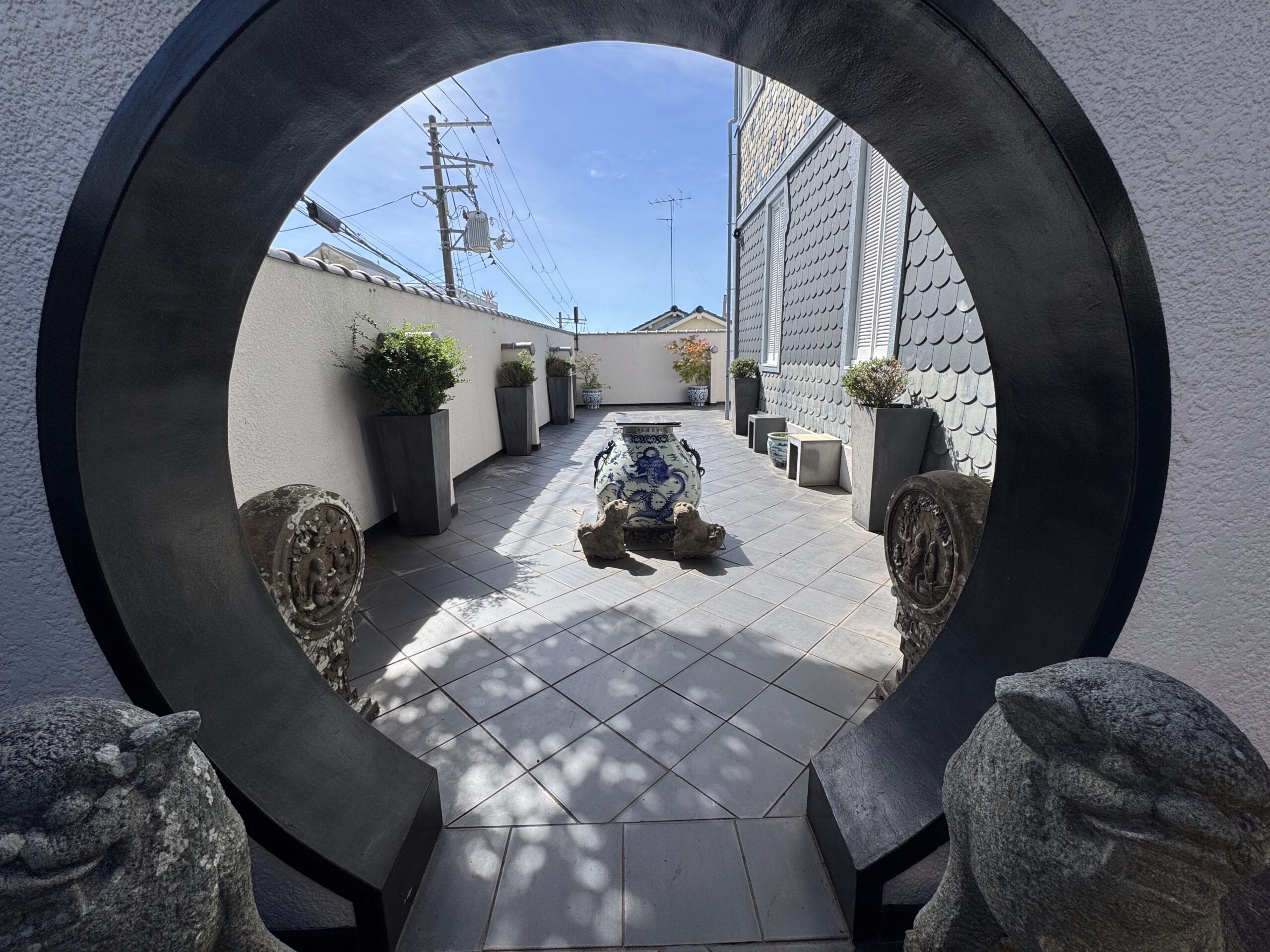 Image of the arch with Komainu, or guardian lion-dog statues, on either side at the Hilltop House. 