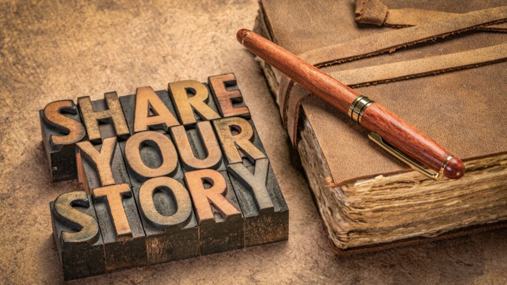 Everybody has one. A story that is. My story is not yours and yours is not mine.  The details vary - except for one thing. God is the Author! NOtebook and a sign on a table that reads "Share Your Story"
