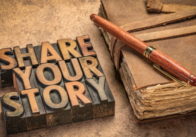 Everybody has one. A story that is. My story is not yours and yours is not mine.  The details vary - except for one thing. God is the Author! NOtebook and a sign on a table that reads "Share Your Story"