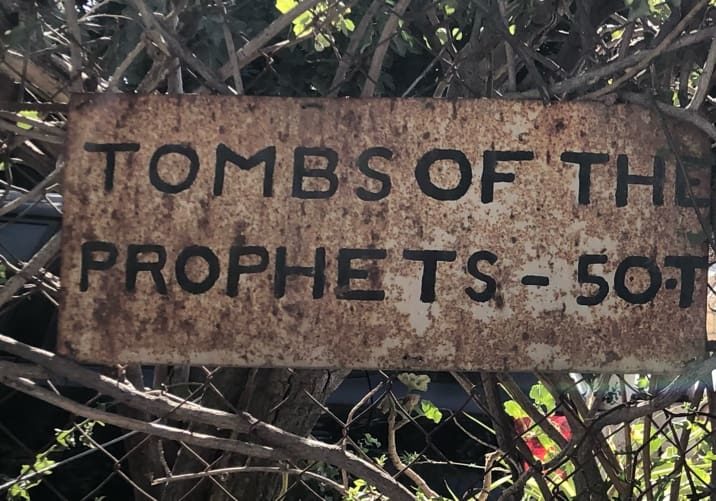 The Tombs of the Prophets

“And his feet shall stand in that day upon the mount of Olives, which is before Jerusalem on the east, and the mount of Olives shall cleave in the midst thereof toward the east and toward the west, and there shall be a very great valley; and half of the mountain shall remove toward the north, and half of it toward the south.” 
Zechariah 14:4

	One of the most overlooked gems in Jerusalem is the Tombs of the Prophets on the Mount of Olives. Every day, thousands of pilgrims on their way up or down the mountain troop past the weatherbeaten sign pointing toward the tombs. Only a few turn in to see it. 
Photos by John Buckner 

	The tombs are believed to belong to Haggai, Zechariah, Malachi, and their disciples. They are located in an enormous man-made cavern in the side of the Mount of Olives. The ancients carved this place near the summit of the Mount of Olives to bury the prophets because of Zechariah’s prophecy about the coming of the Messiah. 
	Once you descend the stairs into the cavern, there is no electricity or signs of modernity. A little light leaks in from the entrance and illuminates the cathedral-like antechamber where the guard will light a candle, hand it to you, and then show you the map of the tombs. He will smile and exhort you to sing, preach, or pray if you feel like it. Believe me, you will!
From there you can wander carefully by candlelight through the corridors and tunnels until you come to the tombs of the great men deep in the mountain. You can find their tombs by the feeble light from a single candle that always burns in front of each of the the three prophet’s graves. A local custom full of symbolism is to kneel, blow out your candle, then relight it from one of theirs. 
Photos from December, 2020.
John Buckner 

	Scholars are not certain if they are the tombs that Jesus mentioned, or if those tombs were elsewhere. Personally, I imagine Him pointing across the Kidron Valley to the tombs, since the entrance to the tombs was visible from the Temple Mount where He was teaching when He said:

“Woe unto you, scribes and Pharisees, hypocrites! because ye build the tombs of the prophets, and garnish the sepulchres of the righteous,” Matthew 23:29

What is known is that the cavern was built by ancient people to honor some great prophets of the Bible. The Tombs of the Prophets have amazing acoustics. I recommend standing somewhere in the dark, and when your meditations on the prophets, and on Jesus’ teachings, ascension, and second coming overcome you, burst into song! It is overwhelming to be near where Jesus will soon return and sing to Him. Whenever I descend the Mount of Olives toward Jerusalem, I always stop and glance back to see if He is there. Every time, I remember that right up there is where He said to “Go ye into all the world and preach the Gospel.” 
	When you go to Jerusalem, and I hope you do, please schedule an hour or two to visit this beautiful memorial to the prophets. Then go forth carrying the light that they preached to a dark world.  

“But unto you that fear my name shall the Sun of righteousness arise with healing in his wings;” Malachi 4:2

“For thus saith the Lord of hosts; Yet once, it is a little while, and I will shake the heavens, and the earth, and the sea, and the dry land; And I will shake all nations, and the desire of all nations shall come: and I will fill this house with glory, saith the Lord of hosts. Haggai 2:6-7