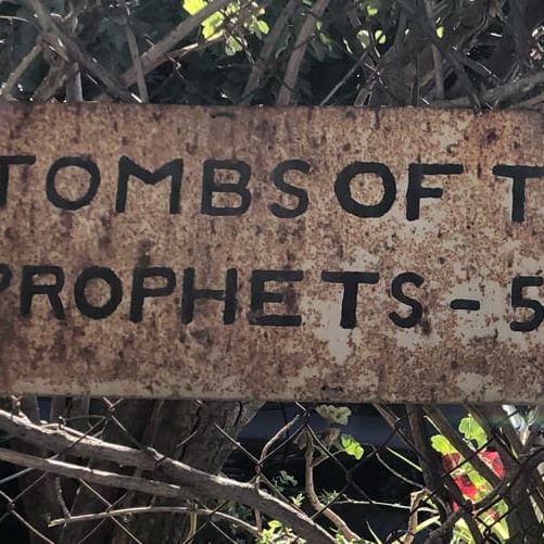 The Tombs of the Prophets

“And his feet shall stand in that day upon the mount of Olives, which is before Jerusalem on the east, and the mount of Olives shall cleave in the midst thereof toward the east and toward the west, and there shall be a very great valley; and half of the mountain shall remove toward the north, and half of it toward the south.” 
Zechariah 14:4

	One of the most overlooked gems in Jerusalem is the Tombs of the Prophets on the Mount of Olives. Every day, thousands of pilgrims on their way up or down the mountain troop past the weatherbeaten sign pointing toward the tombs. Only a few turn in to see it. 
Photos by John Buckner 

	The tombs are believed to belong to Haggai, Zechariah, Malachi, and their disciples. They are located in an enormous man-made cavern in the side of the Mount of Olives. The ancients carved this place near the summit of the Mount of Olives to bury the prophets because of Zechariah’s prophecy about the coming of the Messiah. 
	Once you descend the stairs into the cavern, there is no electricity or signs of modernity. A little light leaks in from the entrance and illuminates the cathedral-like antechamber where the guard will light a candle, hand it to you, and then show you the map of the tombs. He will smile and exhort you to sing, preach, or pray if you feel like it. Believe me, you will!
From there you can wander carefully by candlelight through the corridors and tunnels until you come to the tombs of the great men deep in the mountain. You can find their tombs by the feeble light from a single candle that always burns in front of each of the the three prophet’s graves. A local custom full of symbolism is to kneel, blow out your candle, then relight it from one of theirs. 
Photos from December, 2020.
John Buckner 

	Scholars are not certain if they are the tombs that Jesus mentioned, or if those tombs were elsewhere. Personally, I imagine Him pointing across the Kidron Valley to the tombs, since the entrance to the tombs was visible from the Temple Mount where He was teaching when He said:

“Woe unto you, scribes and Pharisees, hypocrites! because ye build the tombs of the prophets, and garnish the sepulchres of the righteous,” Matthew 23:29

What is known is that the cavern was built by ancient people to honor some great prophets of the Bible. The Tombs of the Prophets have amazing acoustics. I recommend standing somewhere in the dark, and when your meditations on the prophets, and on Jesus’ teachings, ascension, and second coming overcome you, burst into song! It is overwhelming to be near where Jesus will soon return and sing to Him. Whenever I descend the Mount of Olives toward Jerusalem, I always stop and glance back to see if He is there. Every time, I remember that right up there is where He said to “Go ye into all the world and preach the Gospel.” 
	When you go to Jerusalem, and I hope you do, please schedule an hour or two to visit this beautiful memorial to the prophets. Then go forth carrying the light that they preached to a dark world.  

“But unto you that fear my name shall the Sun of righteousness arise with healing in his wings;” Malachi 4:2

“For thus saith the Lord of hosts; Yet once, it is a little while, and I will shake the heavens, and the earth, and the sea, and the dry land; And I will shake all nations, and the desire of all nations shall come: and I will fill this house with glory, saith the Lord of hosts. Haggai 2:6-7